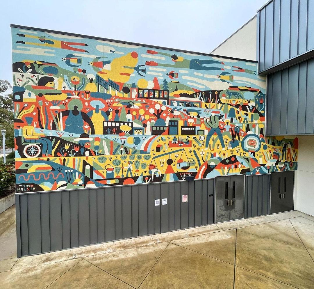 a mural featuring several shapes and outlines in multiple colors on the wall of the arts department buidling at butte college